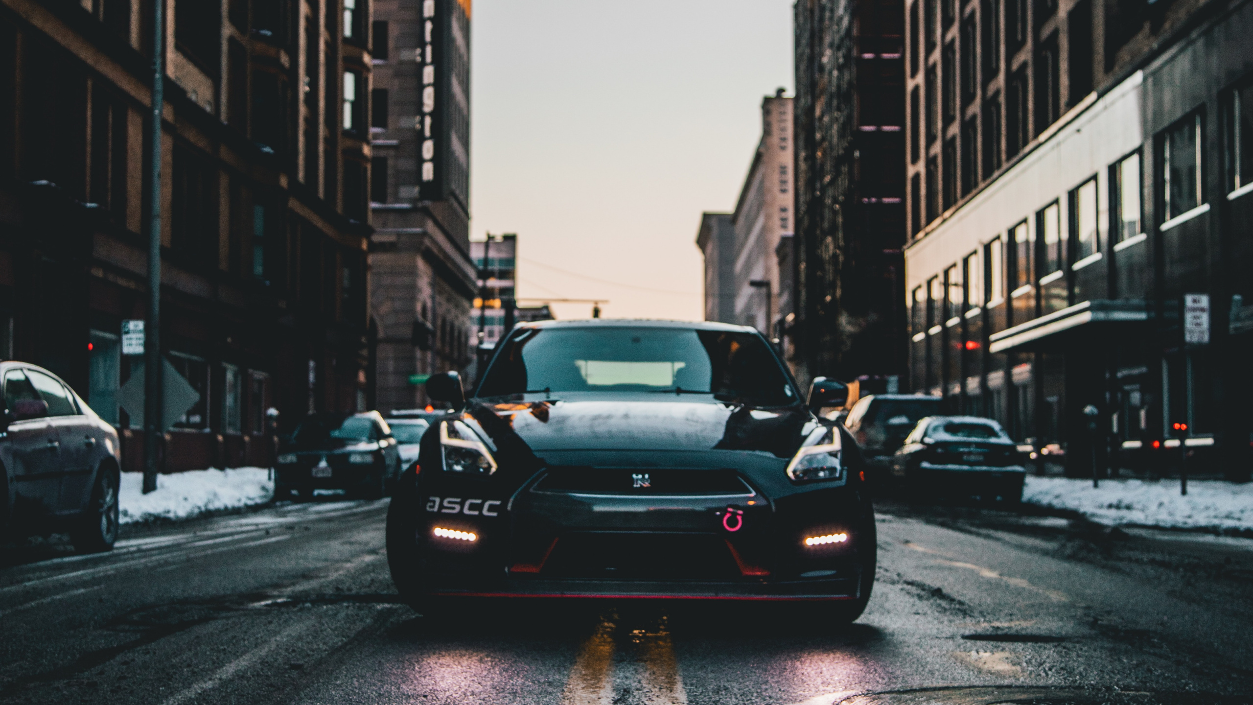 Sedán Negro en la Carretera Entre Edificios de Gran Altura Durante el Día. Wallpaper in 2560x1440 Resolution