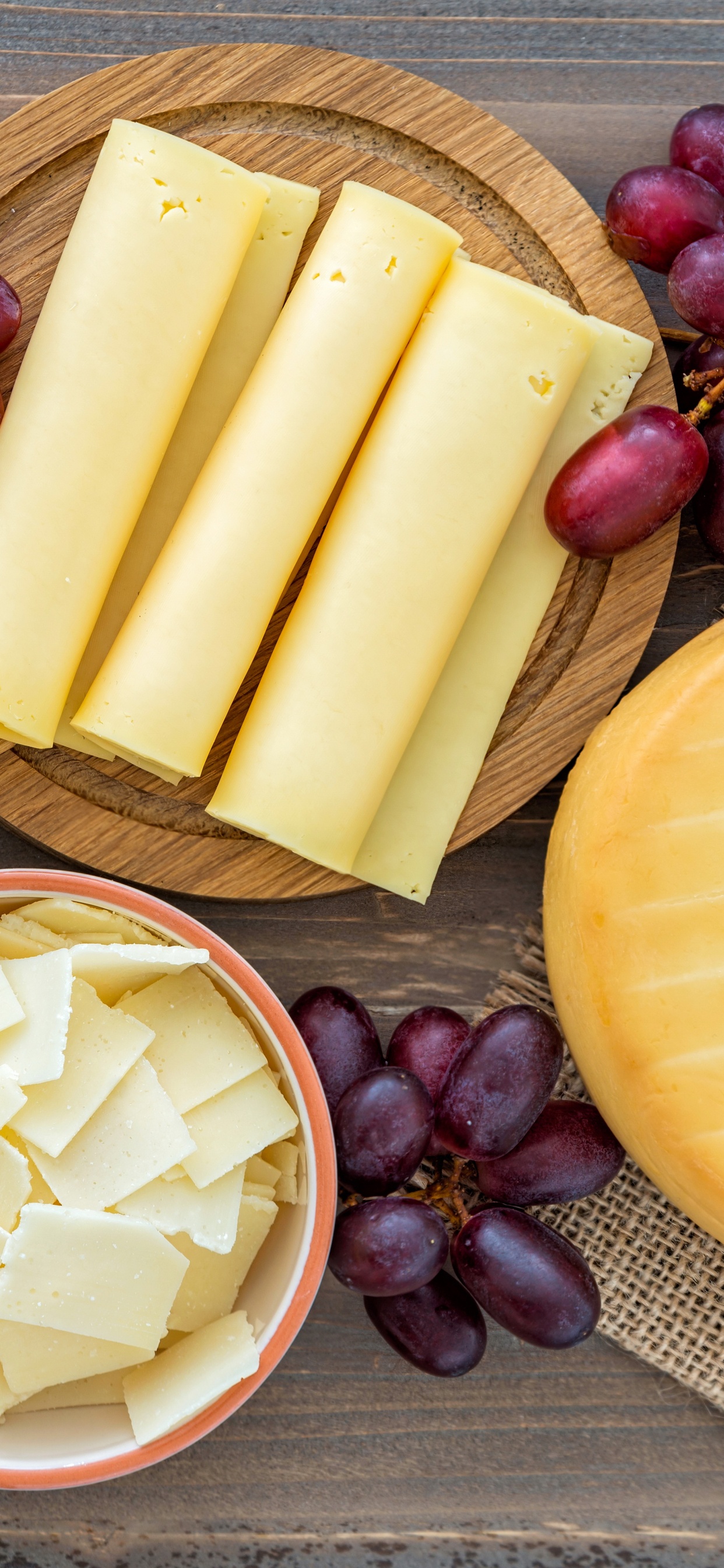 Rebanadas de Queso Sobre Una Tabla de Cortar de Madera Marrón. Wallpaper in 1242x2688 Resolution