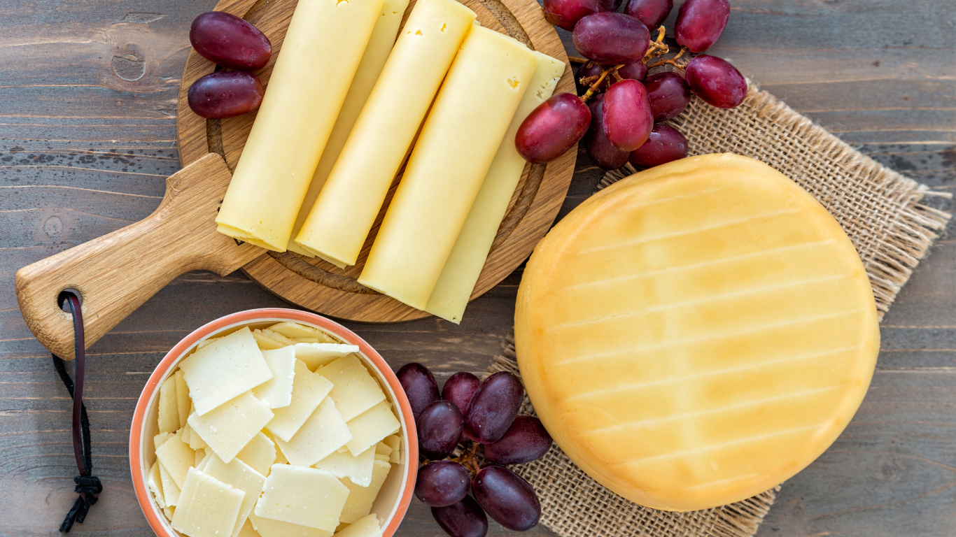 Geschnittener Käse Auf Braunem Holzschneidebrett. Wallpaper in 1366x768 Resolution