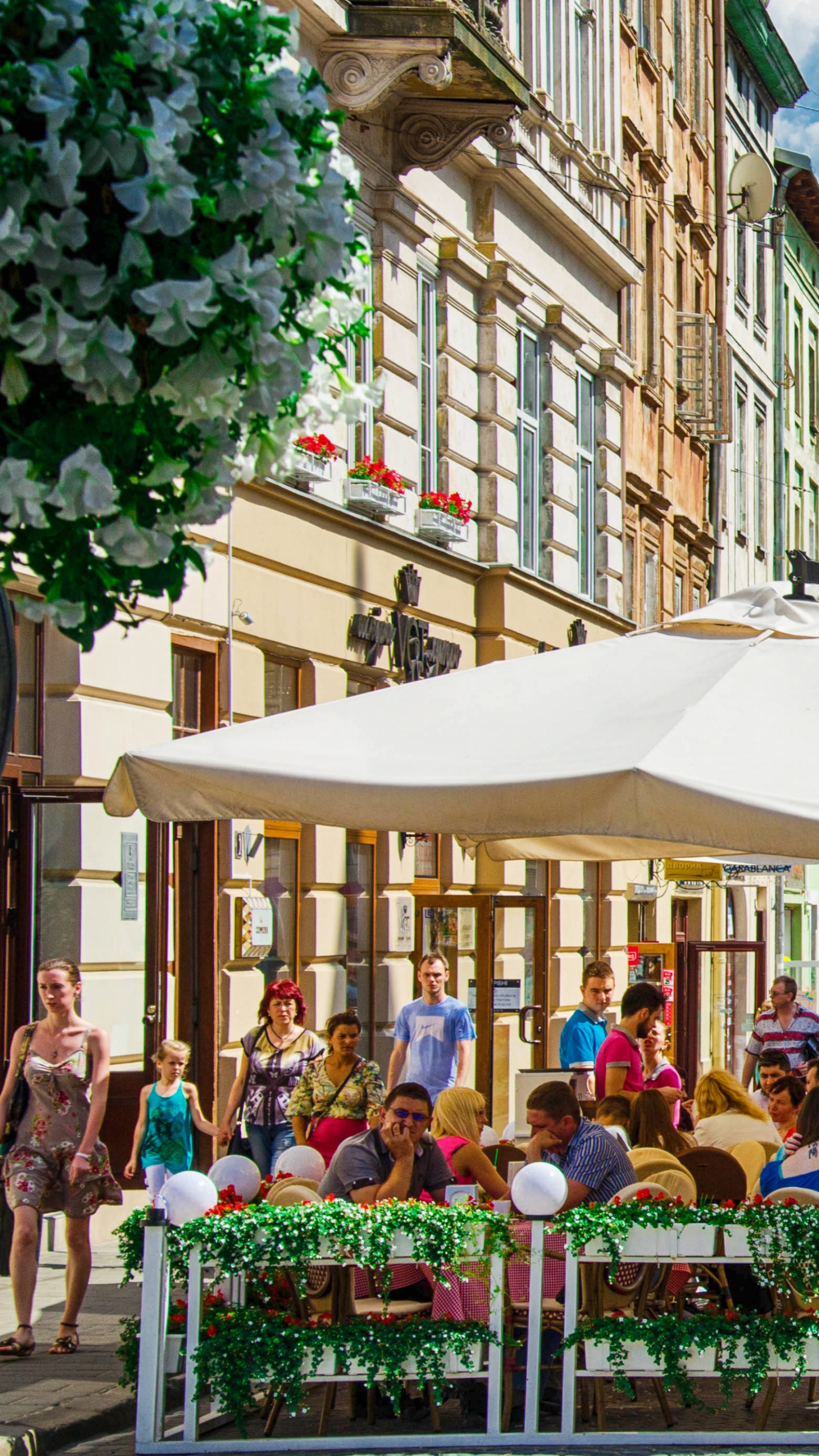 Leute, Die Tagsüber Auf Einer Bank in Der Nähe Eines Braunen Betongebäudes Sitzen. Wallpaper in 1440x2560 Resolution