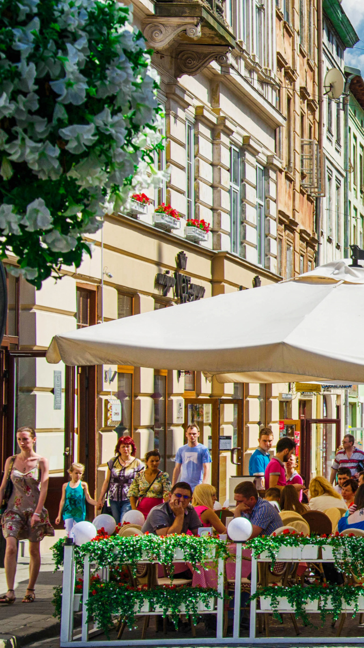 Leute, Die Tagsüber Auf Einer Bank in Der Nähe Eines Braunen Betongebäudes Sitzen. Wallpaper in 750x1334 Resolution