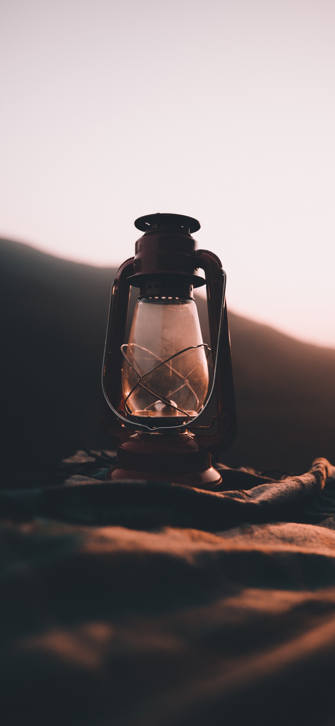 Klarglasflasche Auf Braunem Sand. Wallpaper in 1125x2436 Resolution