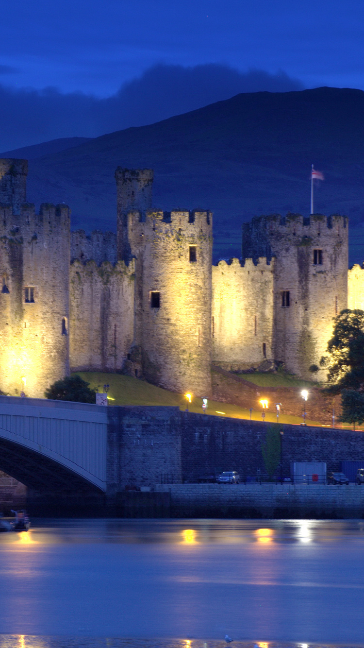 Brown Concrete Castle Near Bridge During Night Time. Wallpaper in 750x1334 Resolution