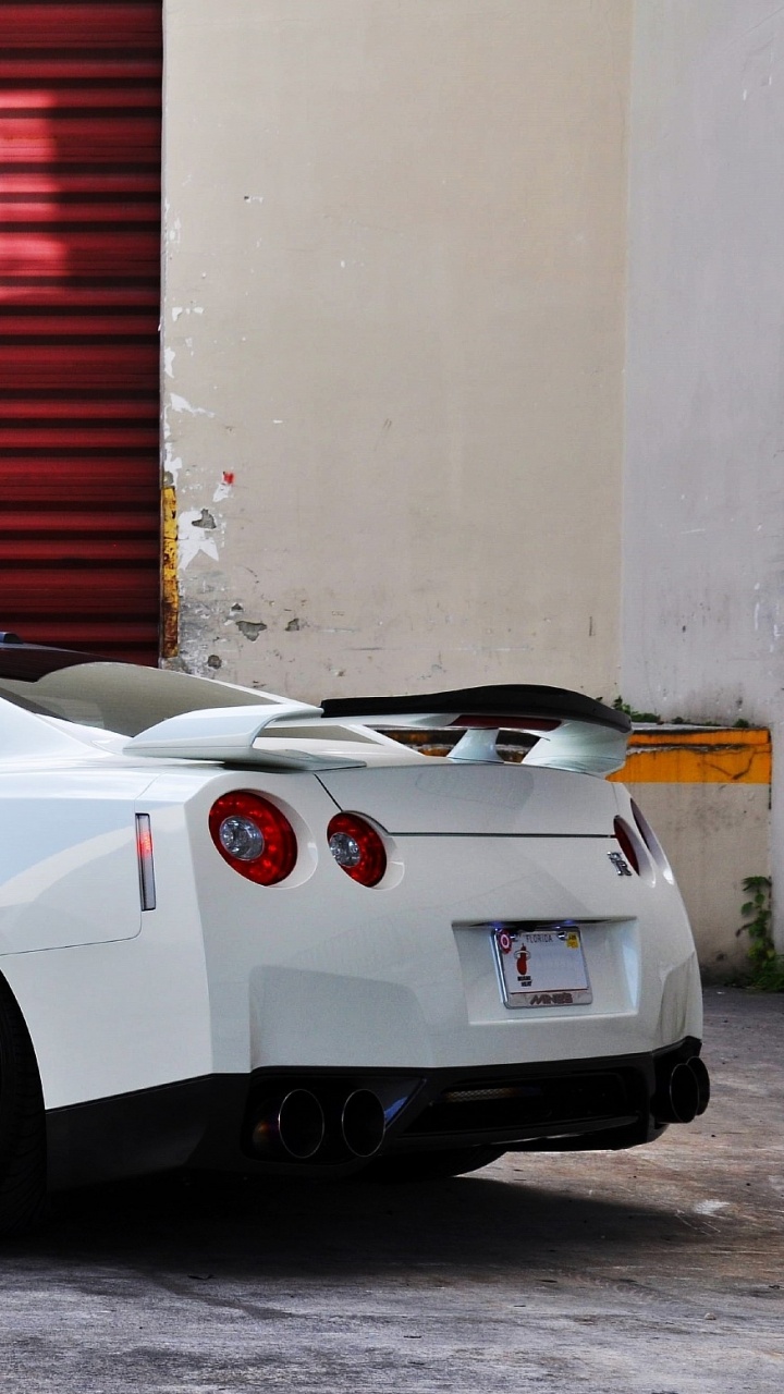 White Porsche 911 Parked Near Red Roll up Door. Wallpaper in 720x1280 Resolution