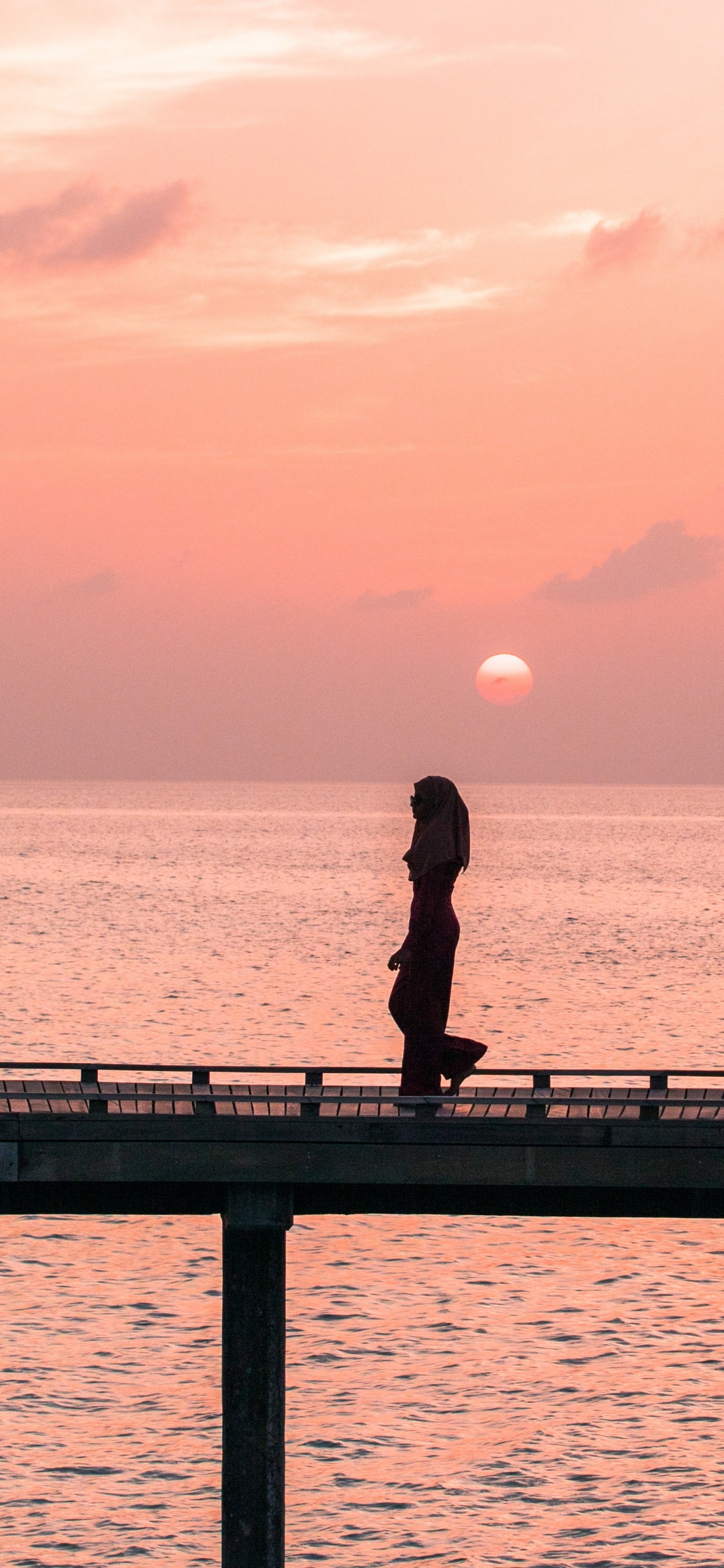 Man in Black Jacket and Pants Standing on Dock During Sunset. Wallpaper in 1242x2688 Resolution