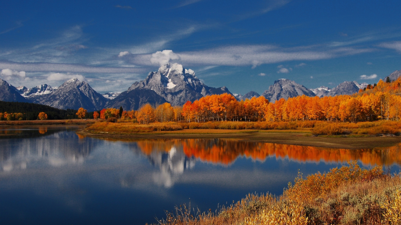Brown Grass Field Near Lake Under Blue Sky During Daytime. Wallpaper in 1280x720 Resolution