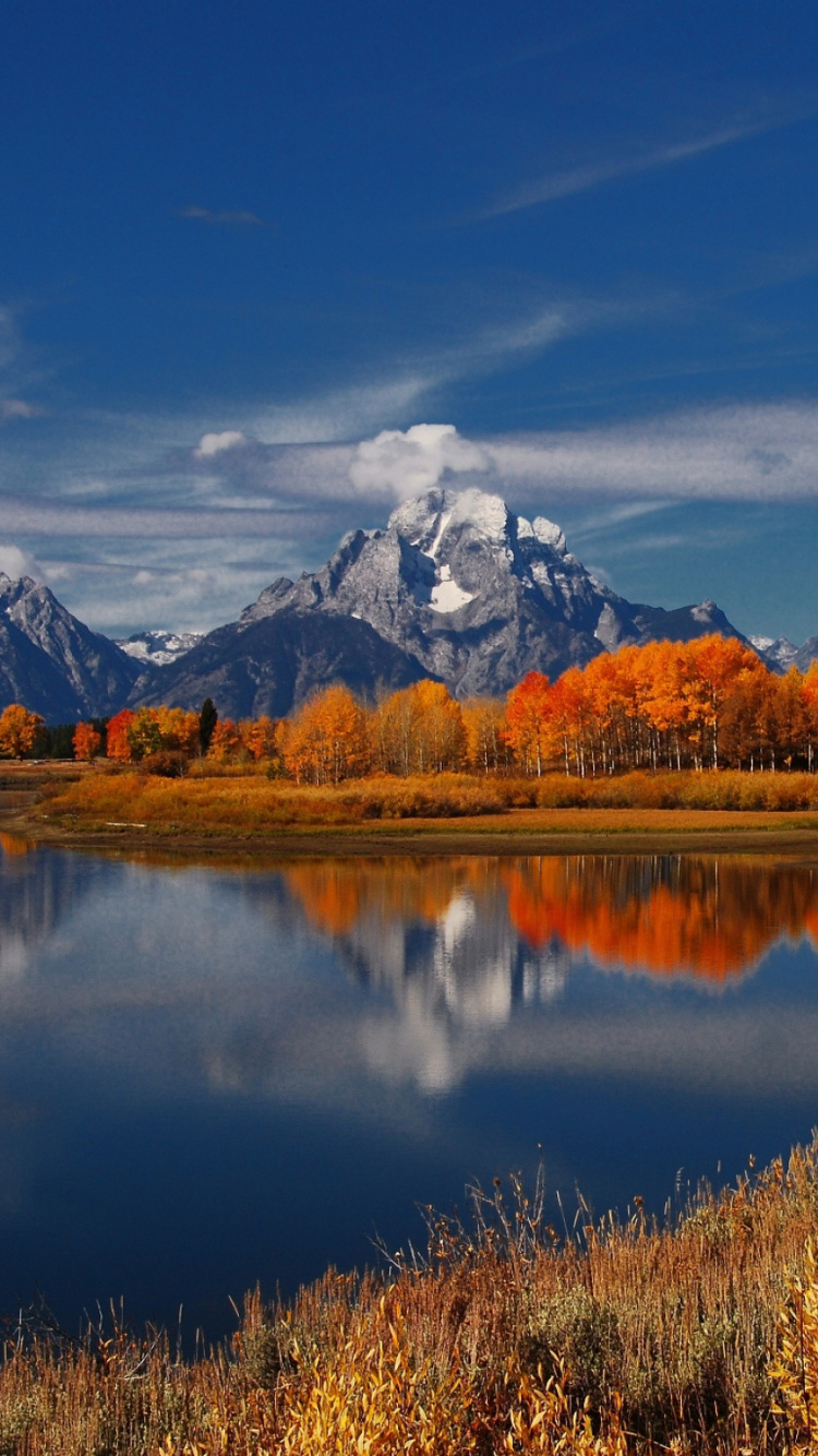 Brown Grass Field Near Lake Under Blue Sky During Daytime. Wallpaper in 750x1334 Resolution