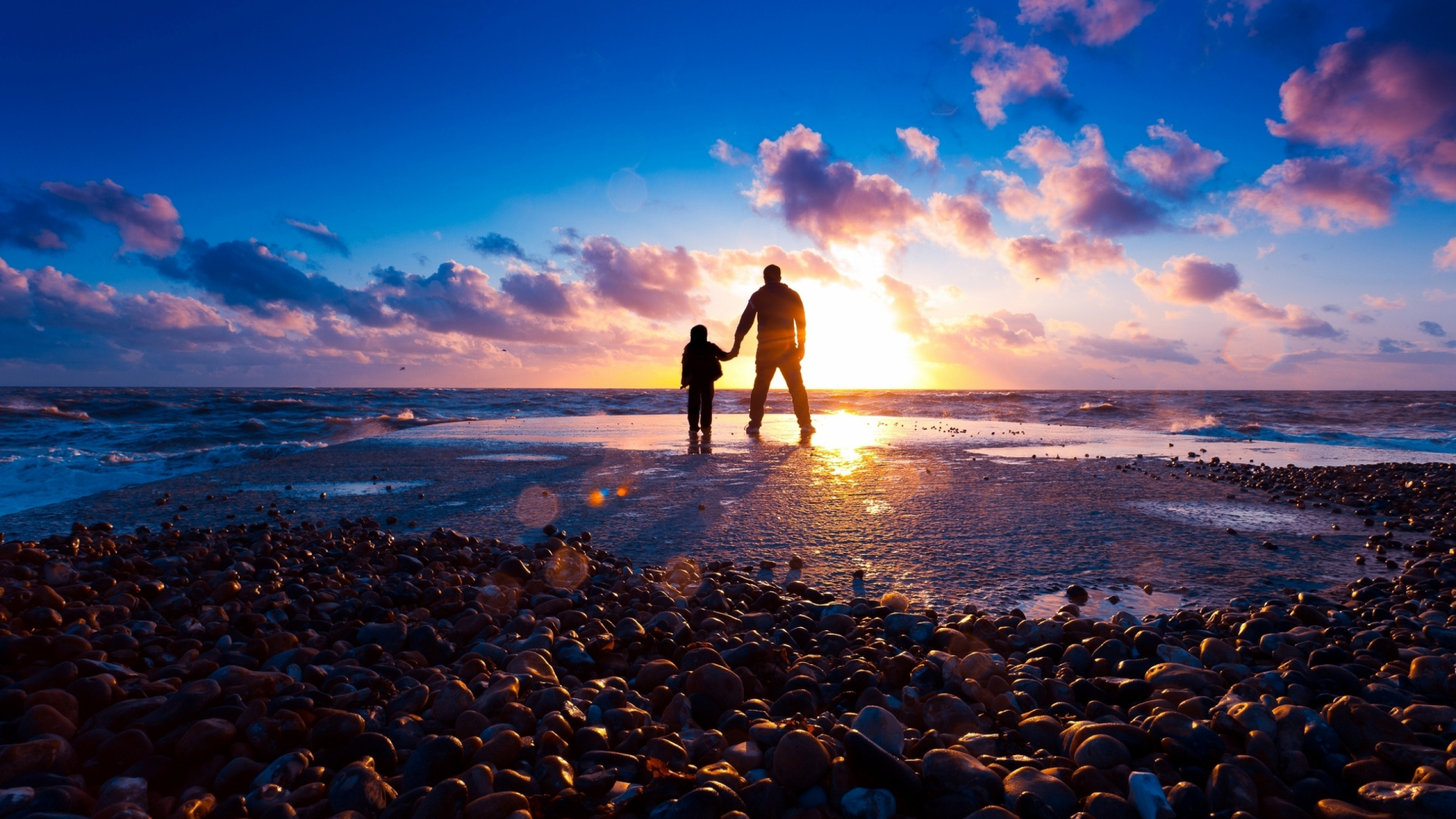 Silhouette of Man and Woman Standing on Rocky Shore During Sunset. Wallpaper in 1920x1080 Resolution