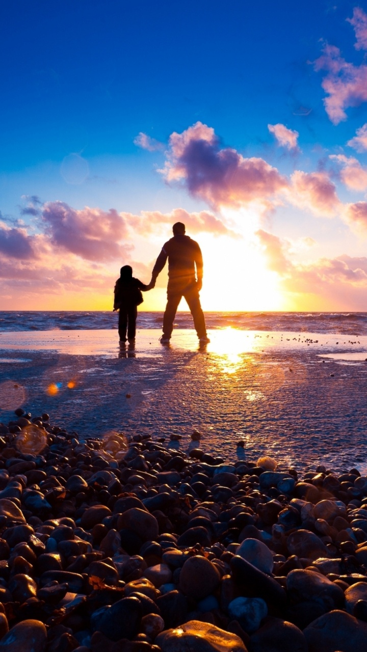 Silhouette of Man and Woman Standing on Rocky Shore During Sunset. Wallpaper in 720x1280 Resolution