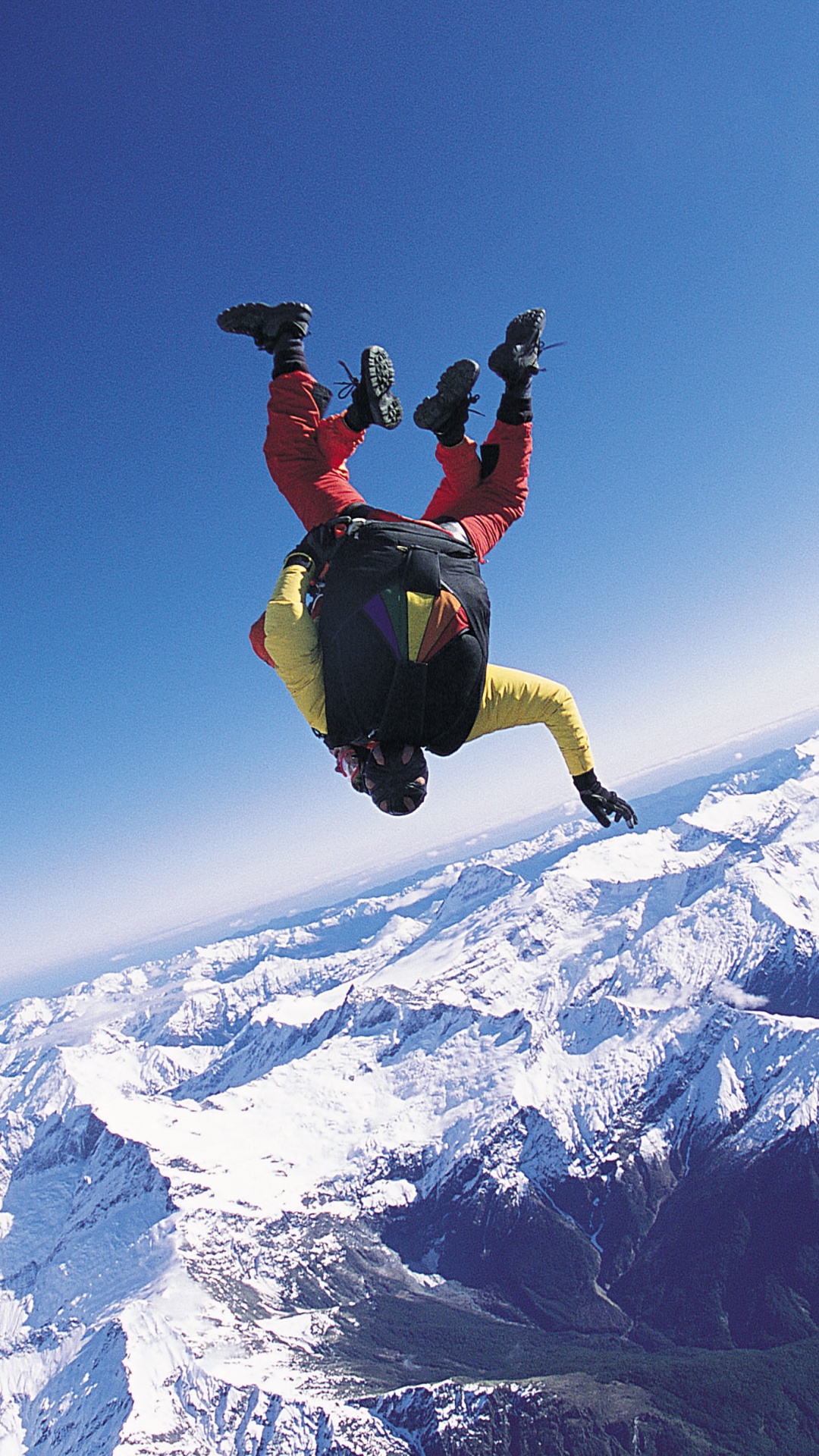 Man in Black Jacket and Black Pants Jumping on Snow Covered Mountain During Daytime. Wallpaper in 1080x1920 Resolution