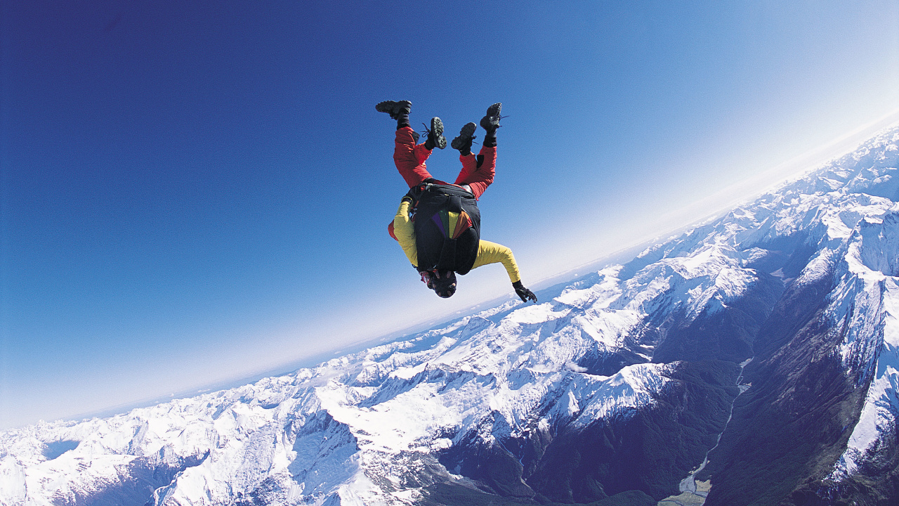 Man in Black Jacket and Black Pants Jumping on Snow Covered Mountain During Daytime. Wallpaper in 1280x720 Resolution