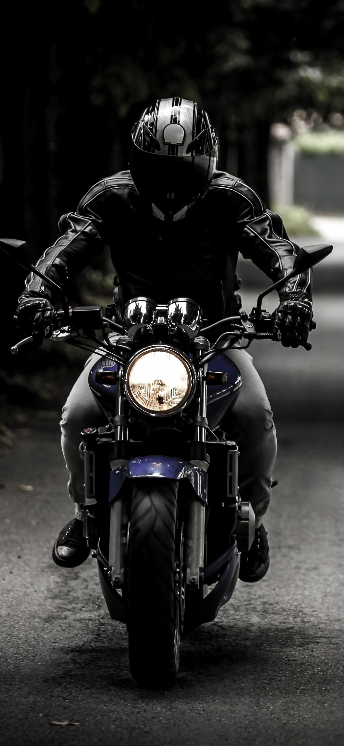 L'homme au Casque Noir Équitation Moto Sur Route Pendant la Journée. Wallpaper in 1125x2436 Resolution