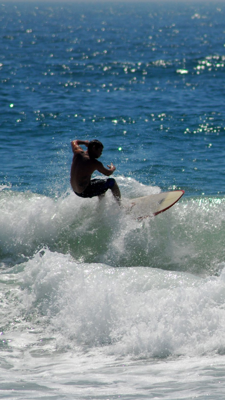 Man Surfing on Sea Waves During Daytime. Wallpaper in 750x1334 Resolution