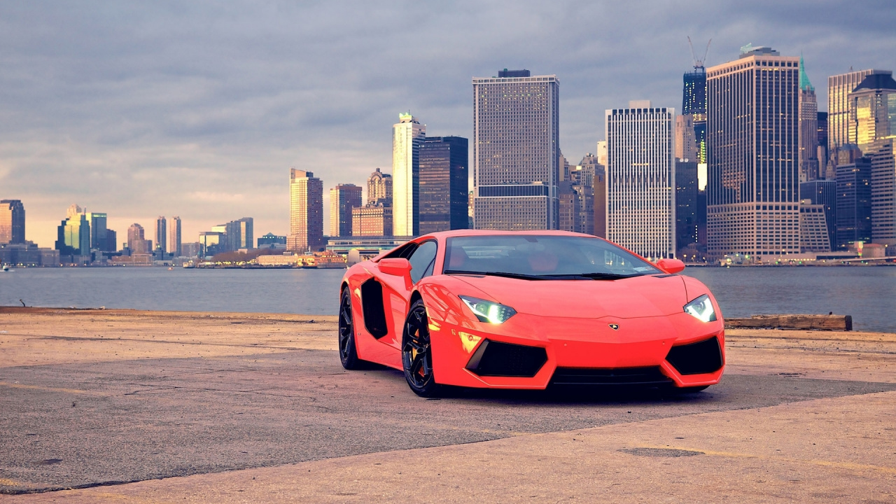 Red Ferrari Sports Car on Road Near City Buildings During Daytime. Wallpaper in 1280x720 Resolution