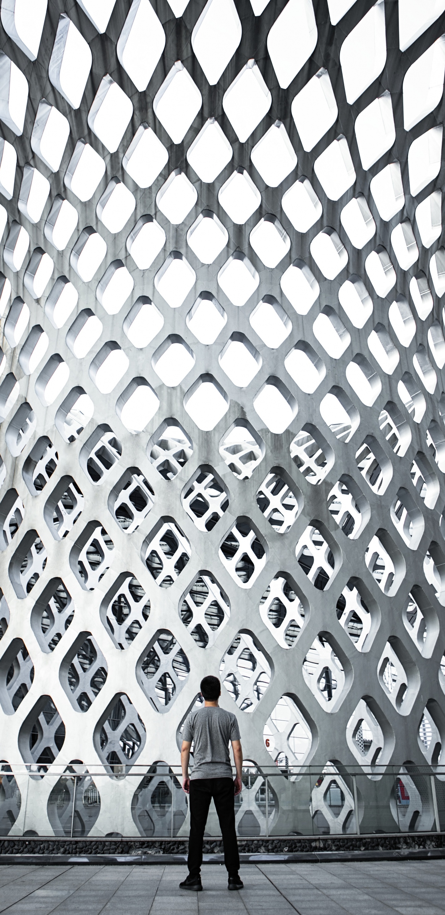 Frau in Schwarzer Jacke Steht Auf Grauem Betongebäude. Wallpaper in 1440x2960 Resolution