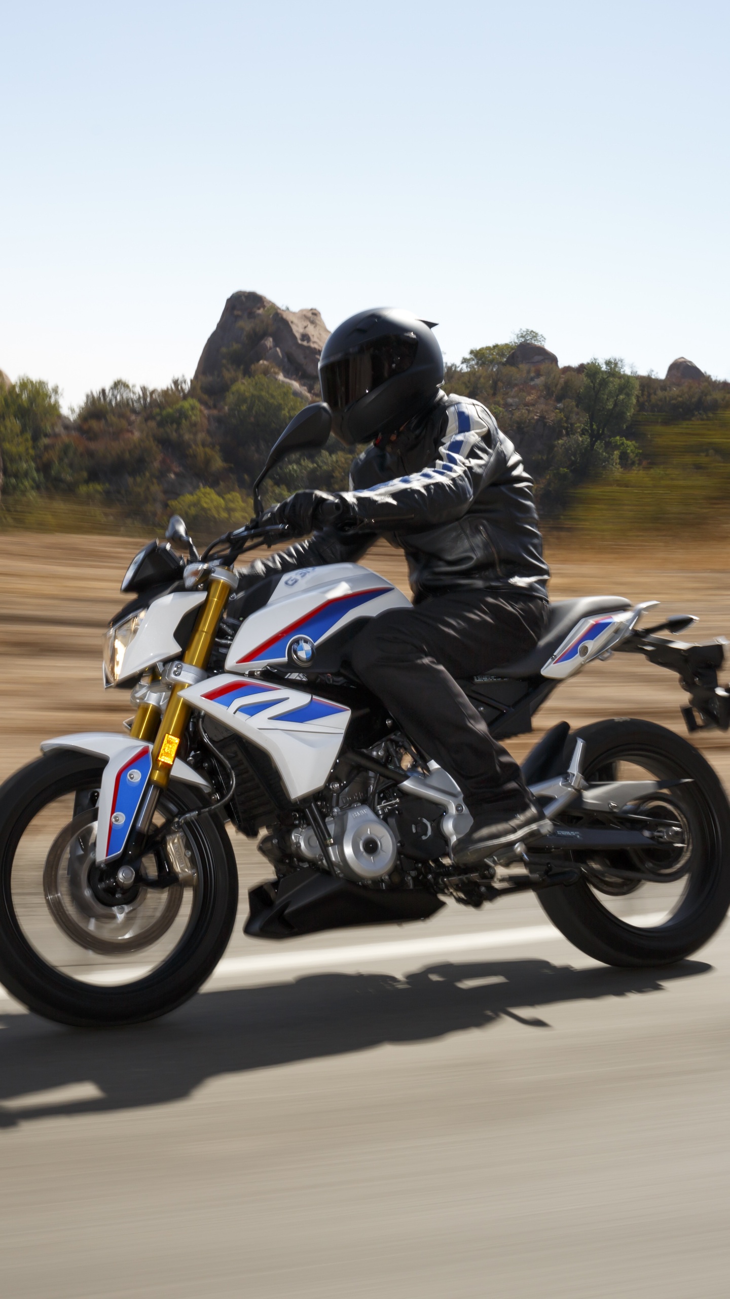 Hombre de Chaqueta Negra Montando Bicicleta Deportiva Azul y Blanca en la Carretera Durante el Día. Wallpaper in 1440x2560 Resolution