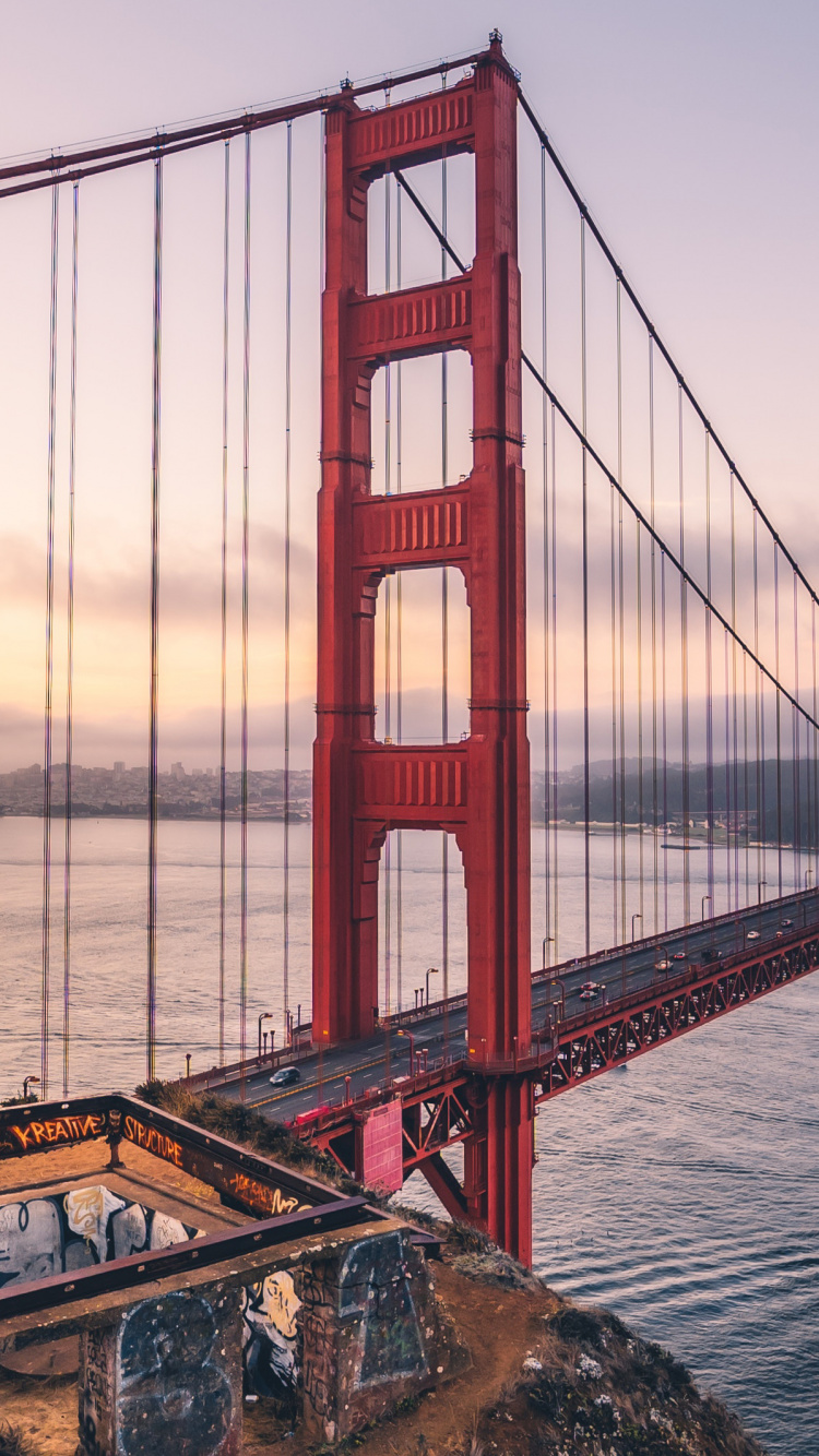 Homme en Veste Noire Debout Sur un Rocher Près du Pont du Golden Gate Pendant la Journée. Wallpaper in 750x1334 Resolution