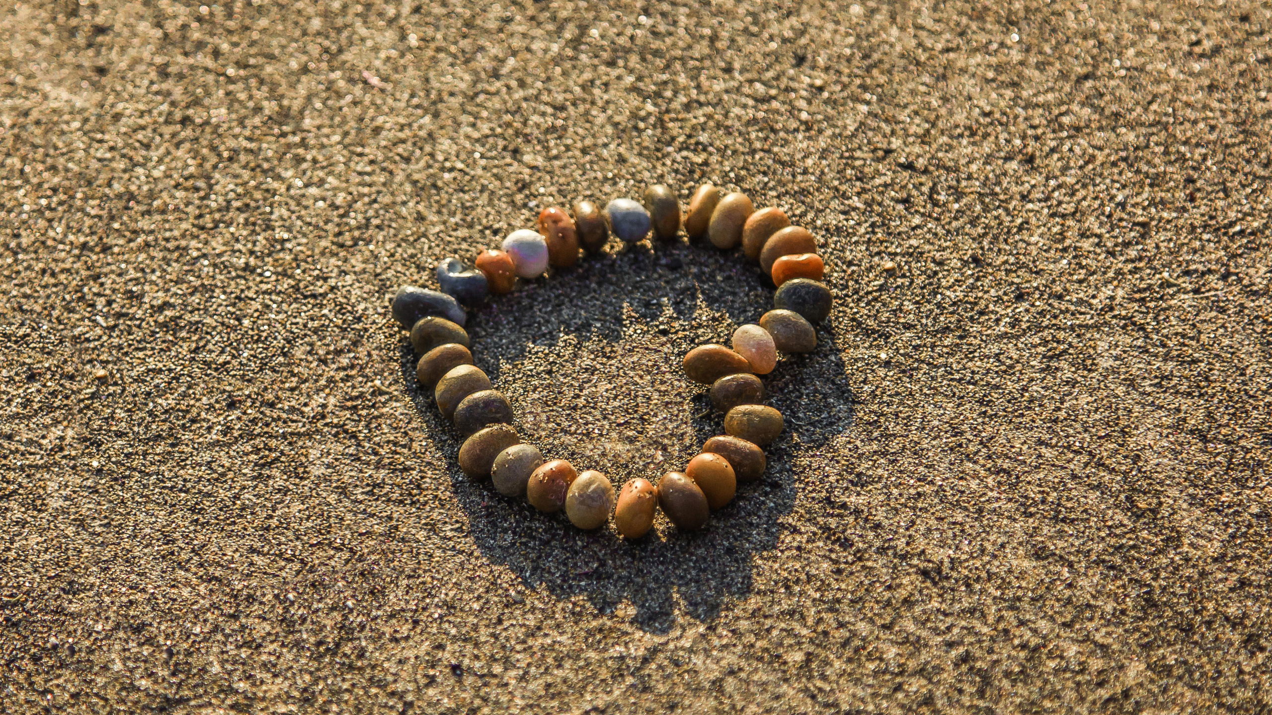 Brown and Black Stones on Brown Sand. Wallpaper in 2560x1440 Resolution