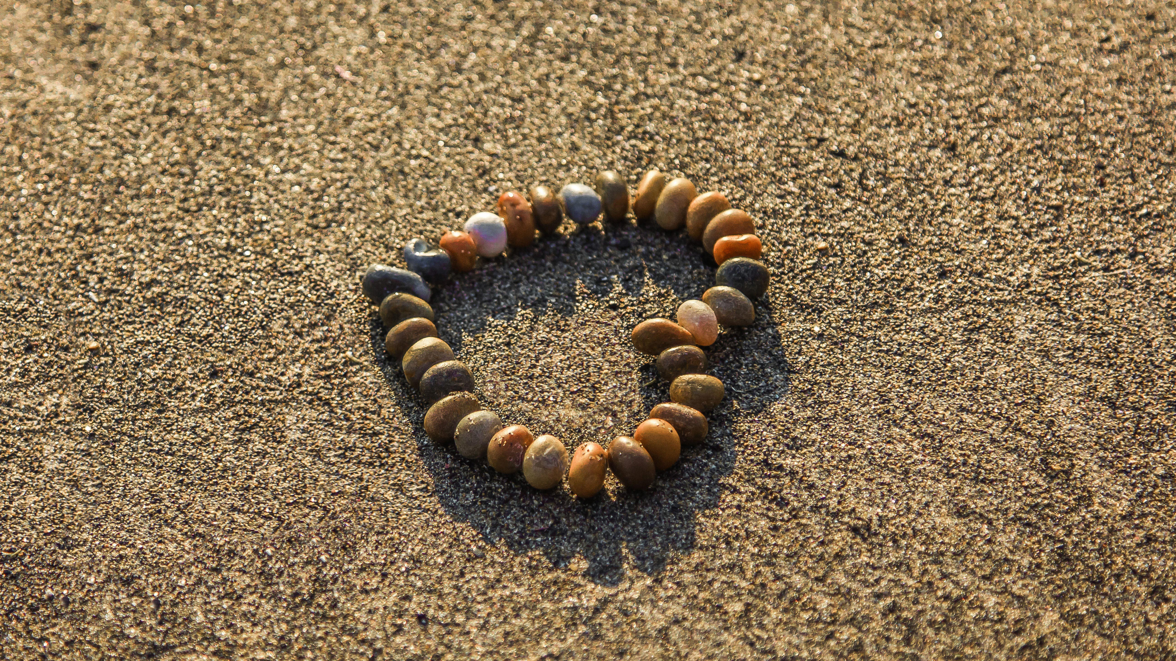 Brown and Black Stones on Brown Sand. Wallpaper in 3840x2160 Resolution