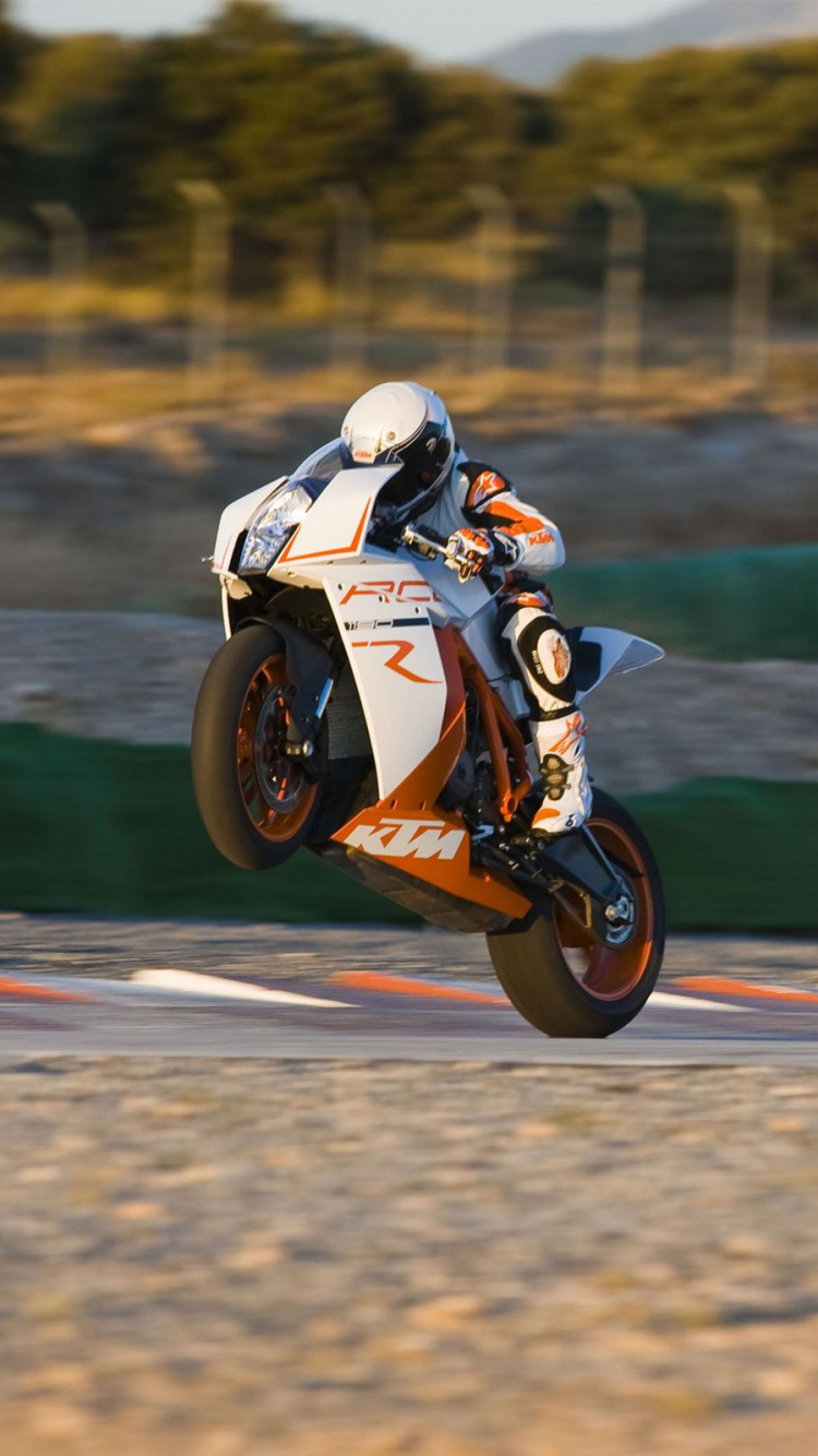 Man Riding Orange and White Sports Bike on Road During Daytime. Wallpaper in 750x1334 Resolution