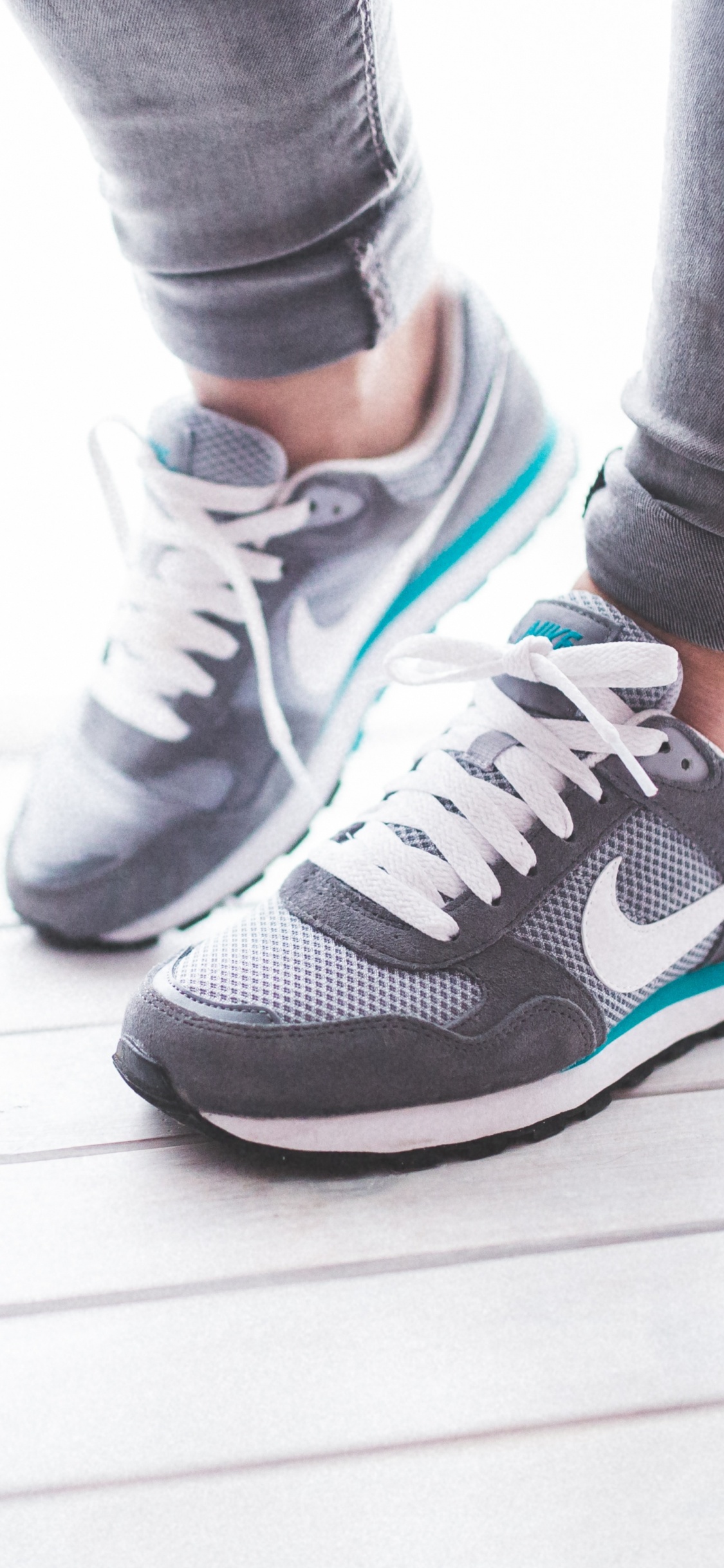 Person in Gray and White Nike Sneakers. Wallpaper in 1125x2436 Resolution
