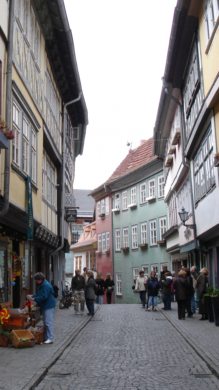 People Walking on Street Between Buildings During Daytime. Wallpaper in 750x1334 Resolution