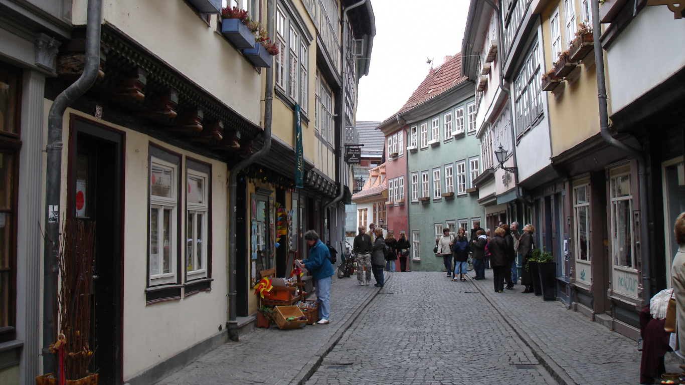 Menschen, Die Tagsüber Auf Der Straße Zwischen Gebäuden Gehen. Wallpaper in 1366x768 Resolution