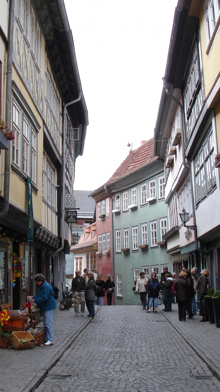 Menschen, Die Tagsüber Auf Der Straße Zwischen Gebäuden Gehen. Wallpaper in 720x1280 Resolution