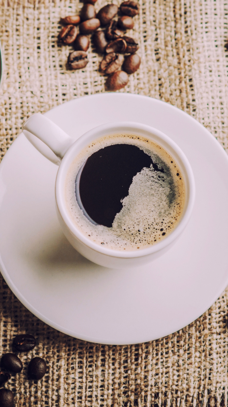 Weiße Keramiktasse Mit Kaffee Neben Edelstahllöffel. Wallpaper in 750x1334 Resolution