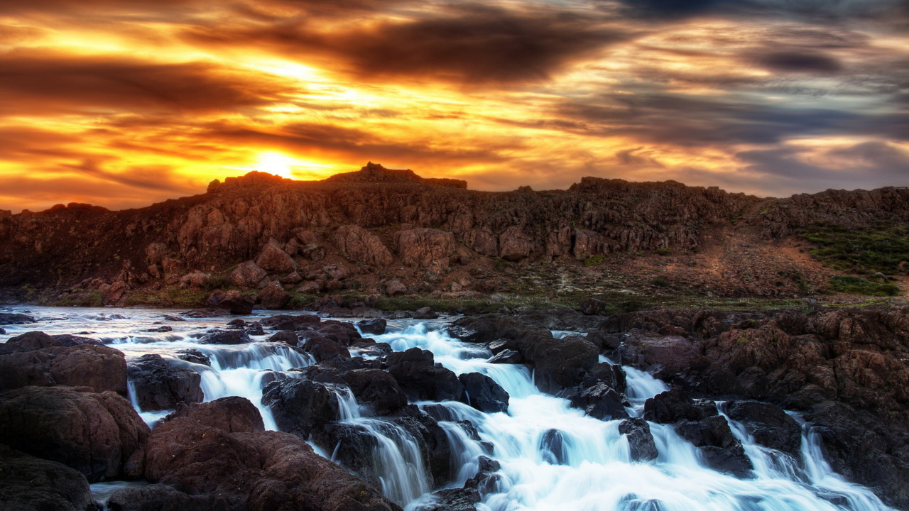 Brauner Felsiger Berg Mit Fluss Bei Sonnenuntergang. Wallpaper in 1280x720 Resolution