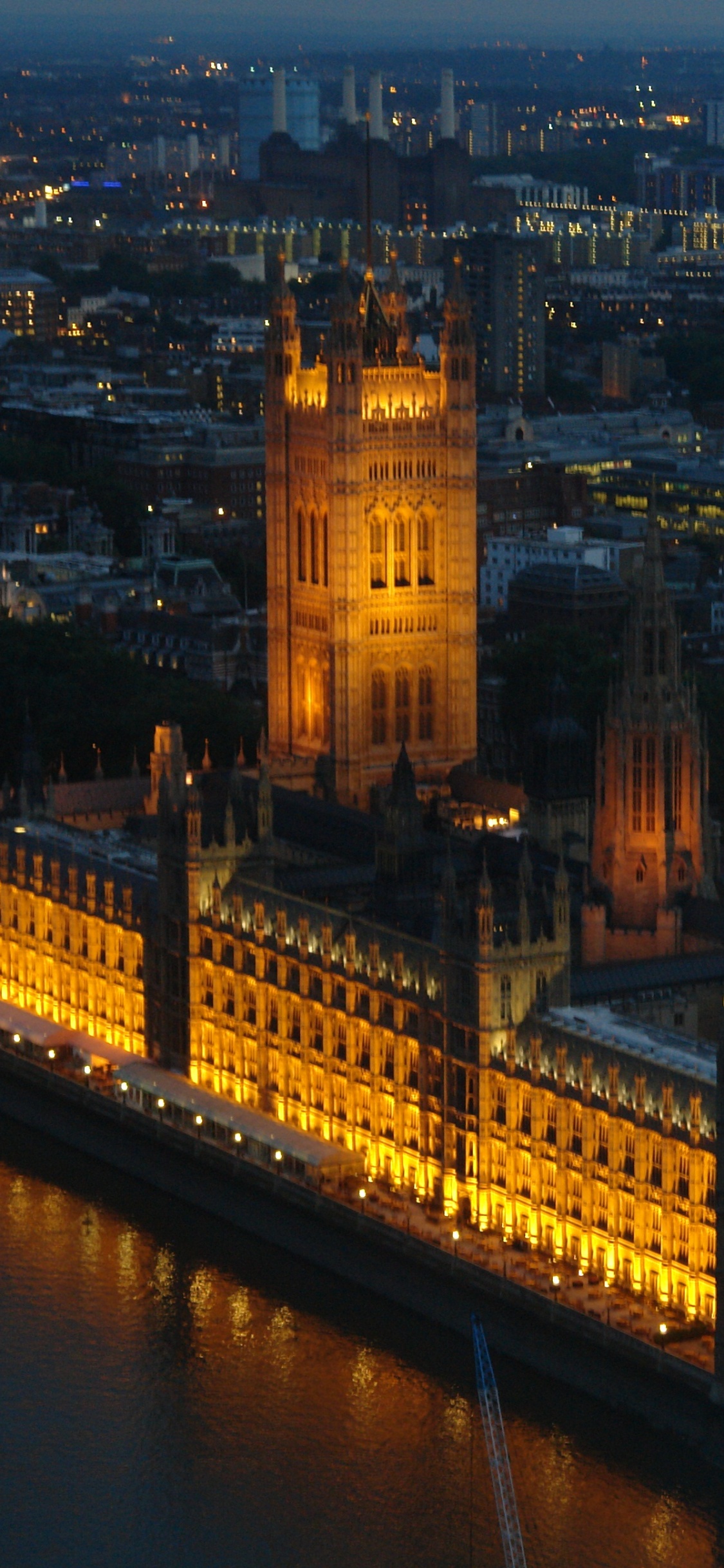 Brown Concrete Building Near Body of Water During Night Time. Wallpaper in 1125x2436 Resolution