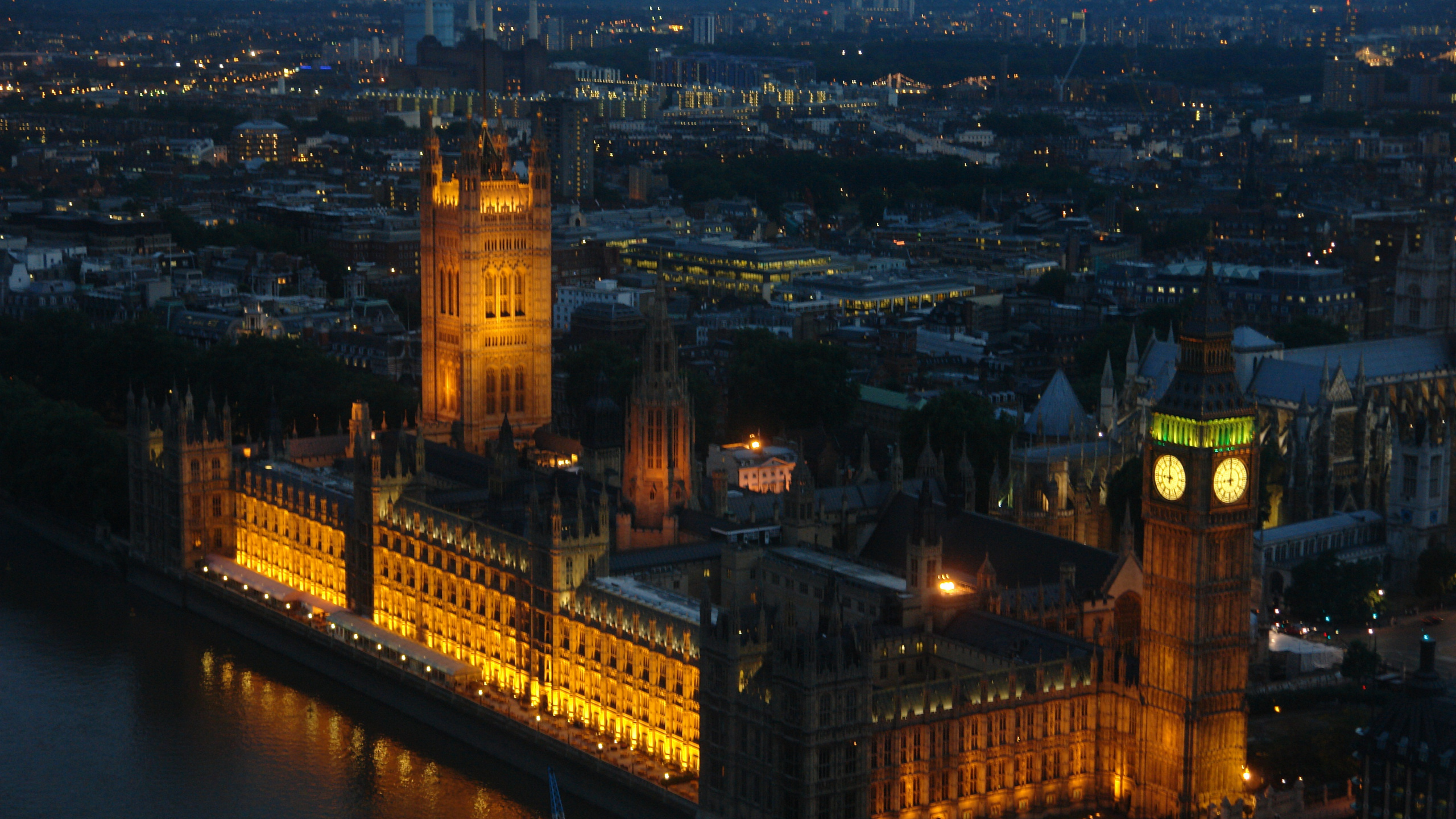 Brown Concrete Building Near Body of Water During Night Time. Wallpaper in 2560x1440 Resolution