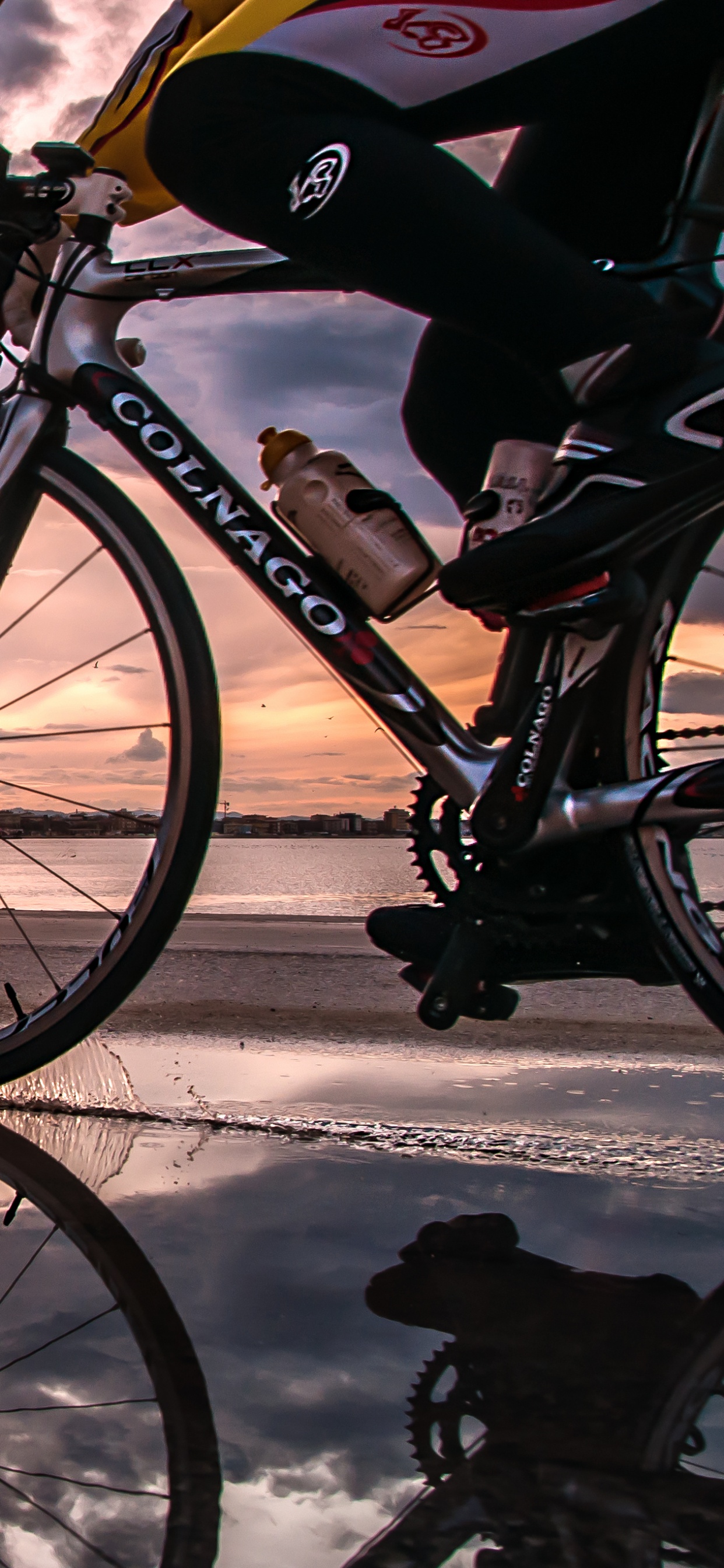Black and White Bicycle on Snow Covered Ground Near Body of Water During Daytime. Wallpaper in 1242x2688 Resolution