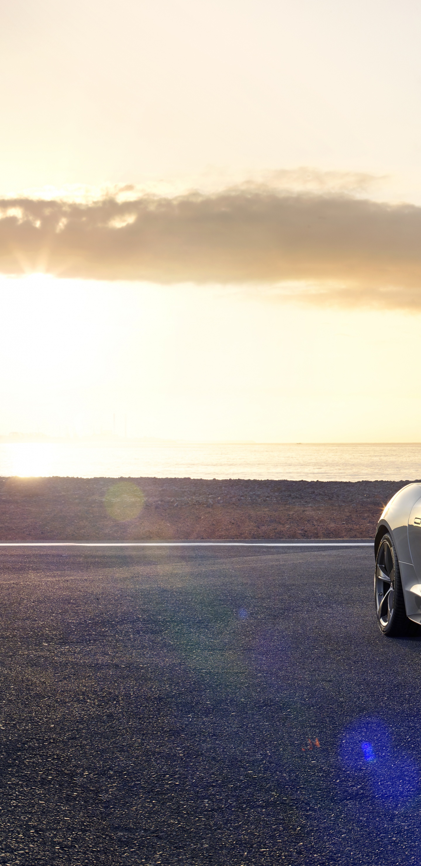 Weißer Porsche 911 am Strand Bei Sonnenuntergang. Wallpaper in 1440x2960 Resolution