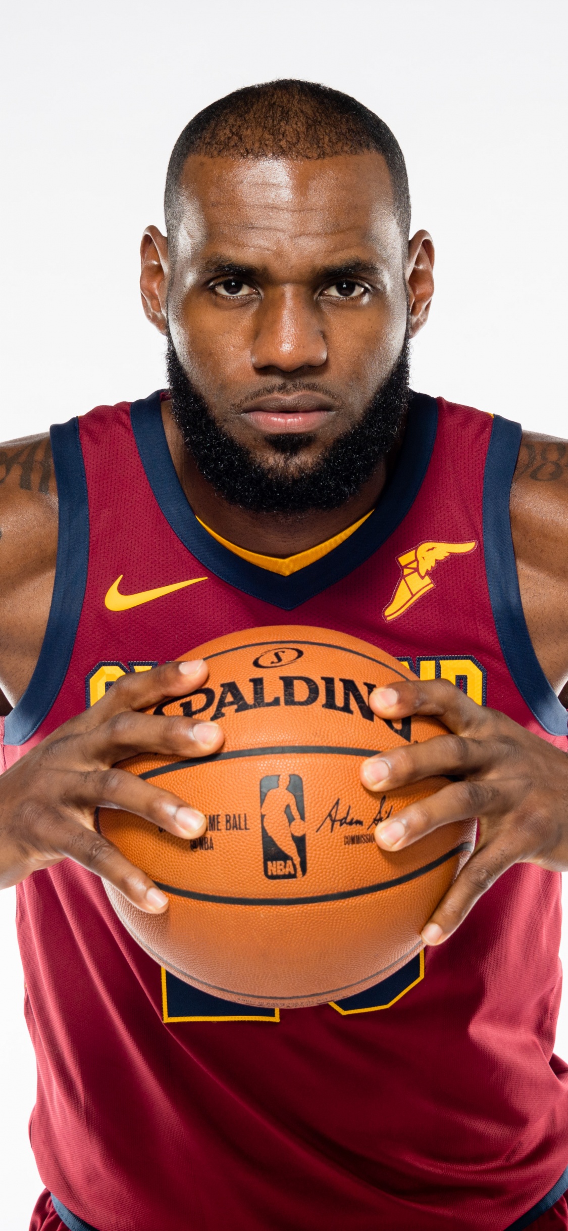 Homme en Rouge et Bleu Débardeur Nike Holding Basketball. Wallpaper in 1125x2436 Resolution