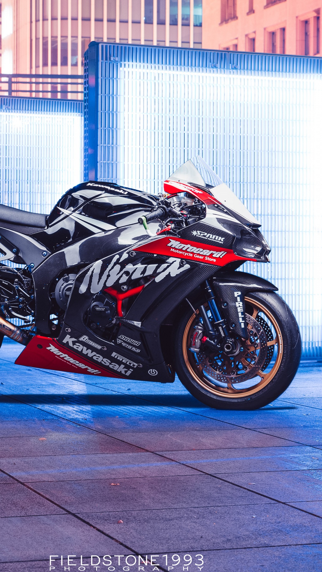 Black Sports Bike Parked Beside White and Blue Building. Wallpaper in 1080x1920 Resolution