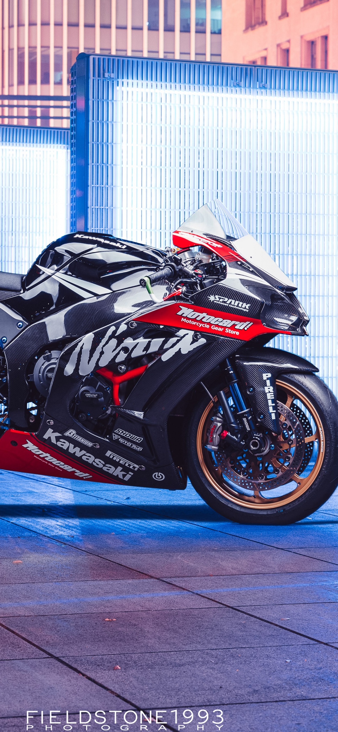 Schwarzes Sportfahrrad Neben Dem Weißen Und Blauen Gebäude Geparkt. Wallpaper in 1125x2436 Resolution