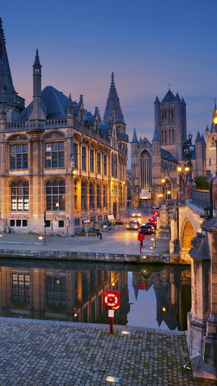Brown Concrete Building Near Body of Water During Night Time. Wallpaper in 750x1334 Resolution