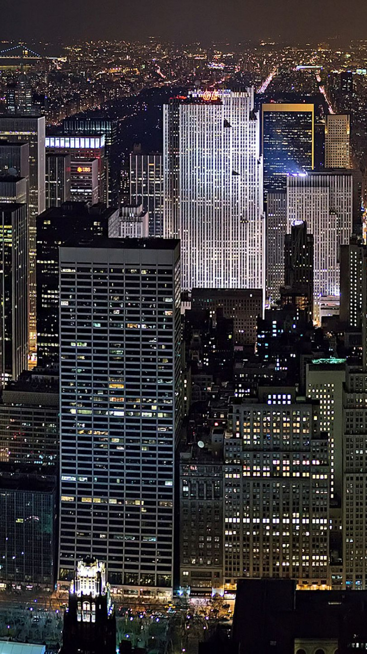 Vista Aérea de Los Edificios de la Ciudad Durante la Noche.. Wallpaper in 750x1334 Resolution