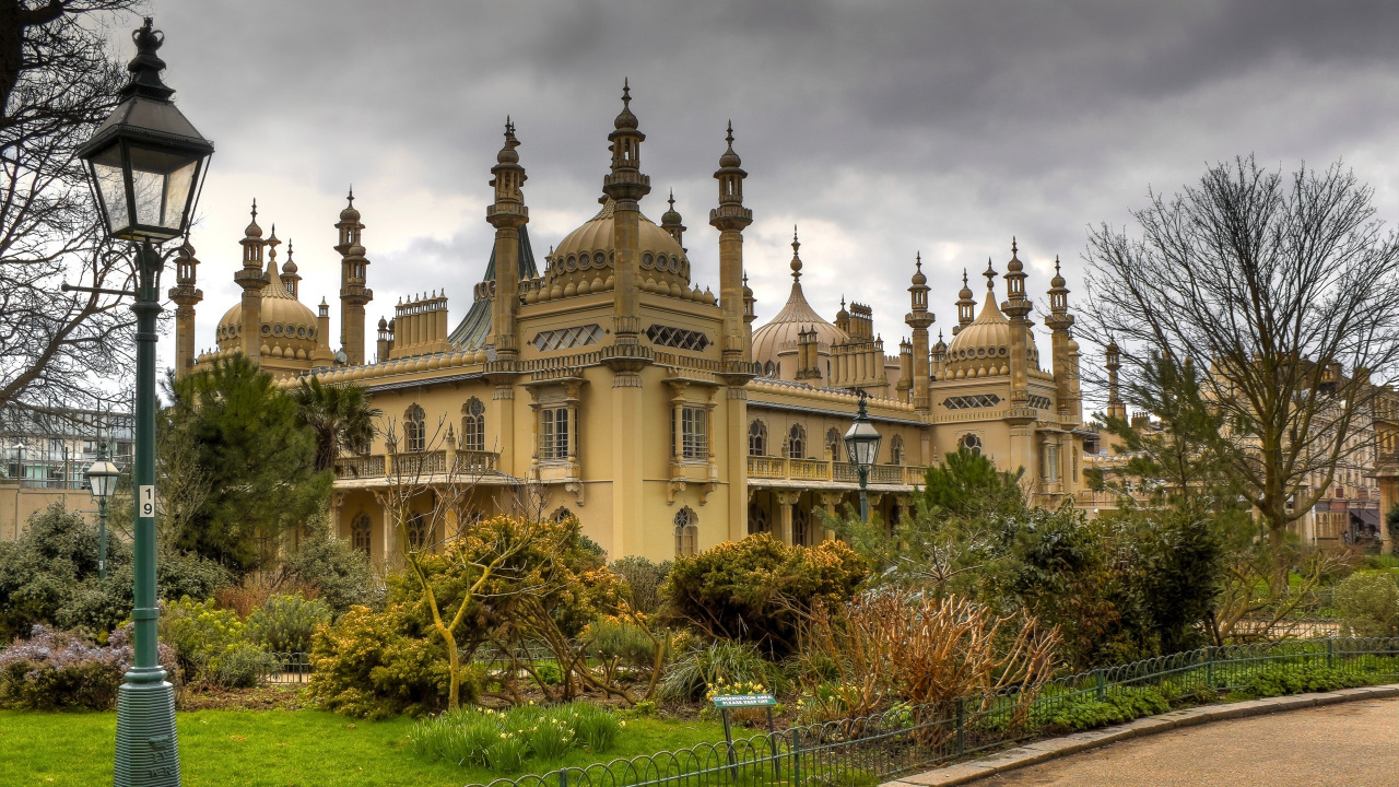 Brown Concrete Building Near Green Grass Field Under Gray Clouds During Daytime. Wallpaper in 1280x720 Resolution
