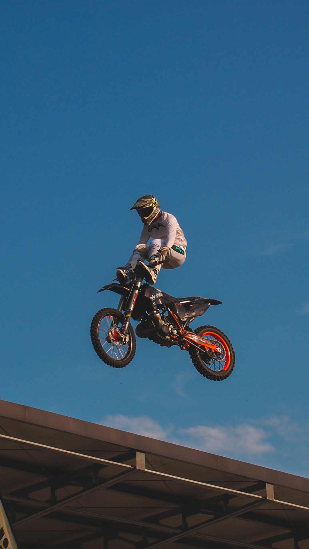 Man Riding Motocross Dirt Bike Sous Ciel Bleu Pendant la Journée. Wallpaper in 1080x1920 Resolution
