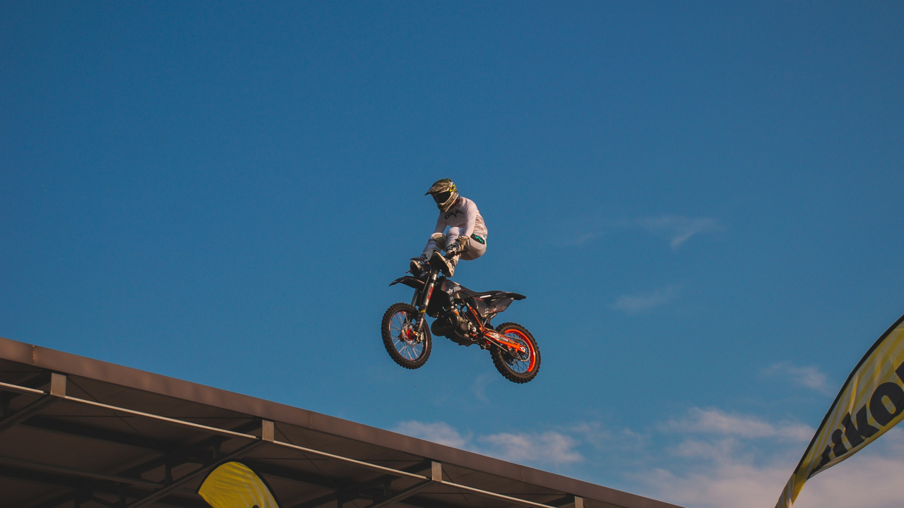 Man Riding Motocross Dirt Bike Under Blue Sky During Daytime. Wallpaper in 1280x720 Resolution