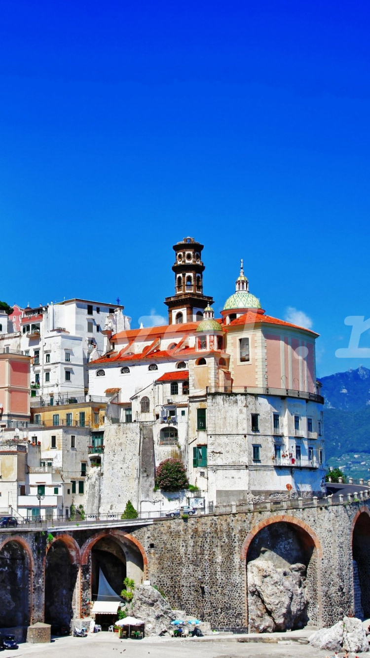 White and Brown Concrete Building Near Green Trees Under Blue Sky During Daytime. Wallpaper in 750x1334 Resolution