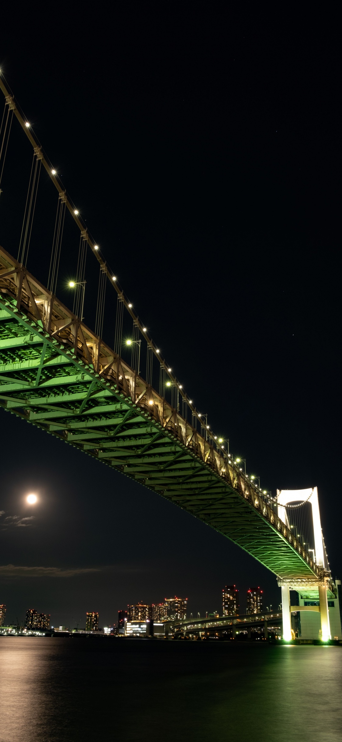 Pont Vert Avec Des Lumières Pendant la Nuit. Wallpaper in 1125x2436 Resolution
