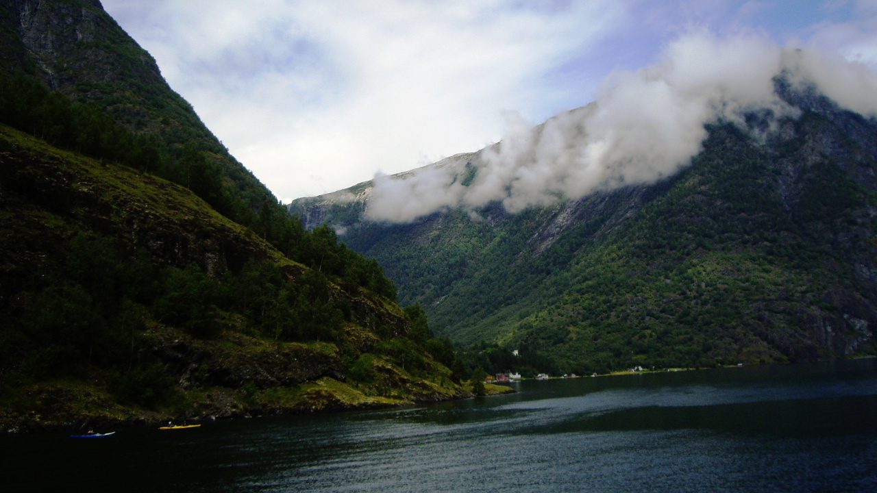Green Mountain Beside Body of Water Under Cloudy Sky During Daytime. Wallpaper in 1280x720 Resolution