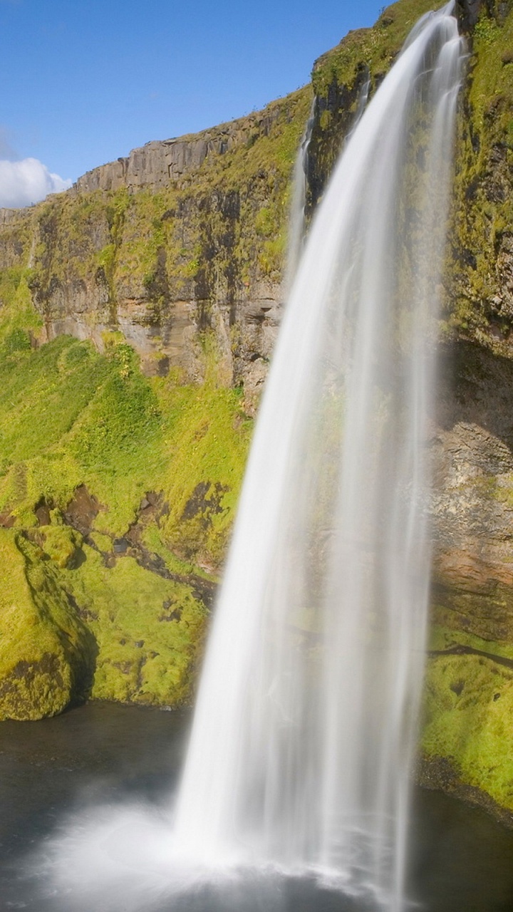 Waterfalls on Green Grass Covered Hill Under Blue Sky During Daytime. Wallpaper in 720x1280 Resolution