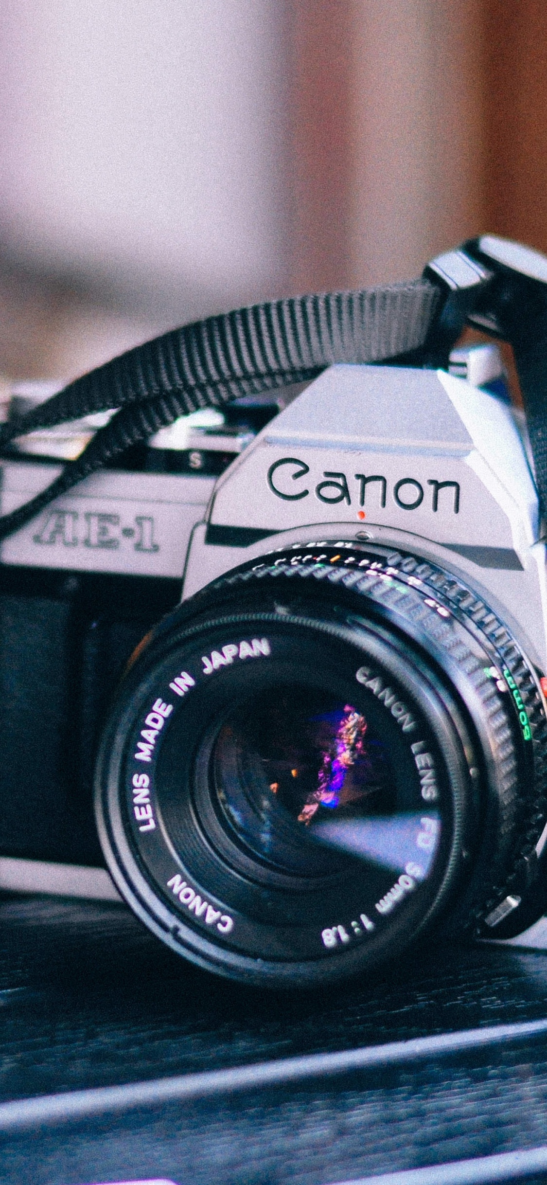 Cámara Réflex Digital Nikon Negra Sobre Mesa de Madera Marrón. Wallpaper in 1125x2436 Resolution