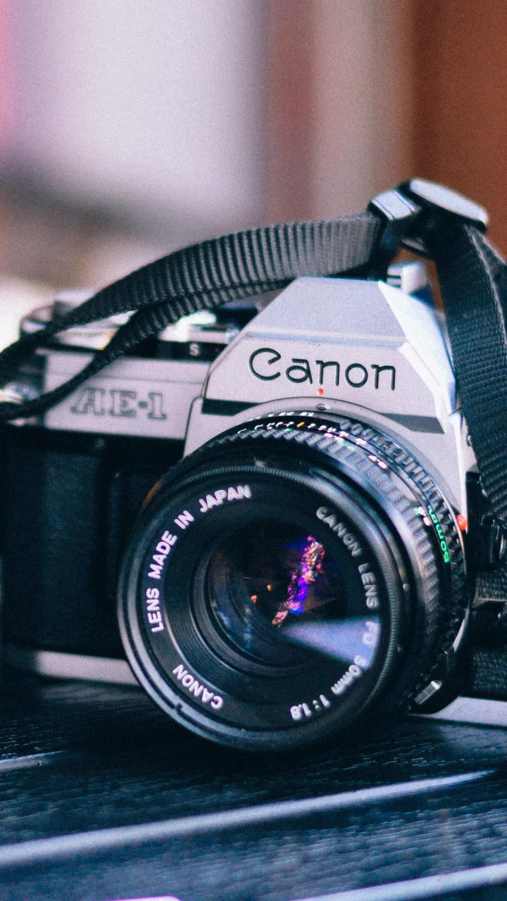 Schwarze Nikon Dslr Kamera Auf Braunem Holztisch. Wallpaper in 720x1280 Resolution