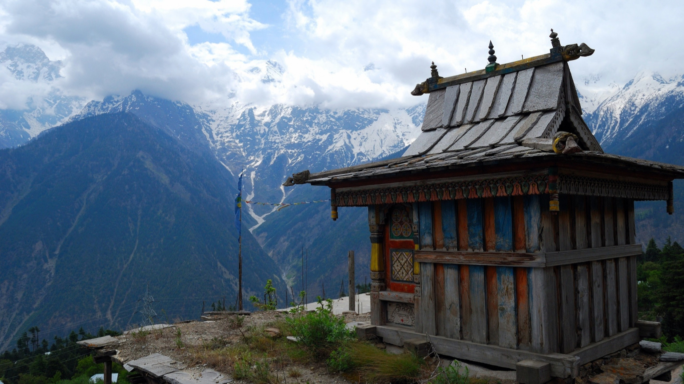 Casa de Madera Marrón en el Campo de Hierba Verde Cerca de la Montaña Durante el Día. Wallpaper in 1366x768 Resolution