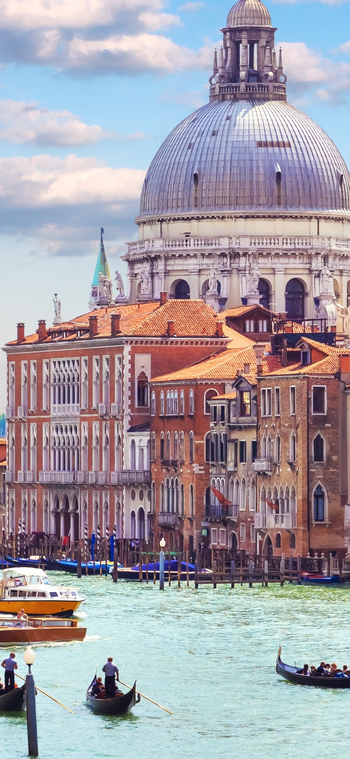 La Gente Que Viaja en Barco en el Cuerpo de Agua Cerca Del Edificio de Hormigón Marrón Durante el Día. Wallpaper in 1125x2436 Resolution